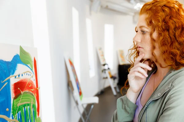 Jeune femme caucasienne dans la galerie d'art devant les peintures — Photo