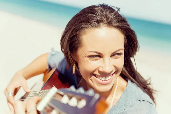 Belle jeune femme jouant de la guitare sur la plage — Photo