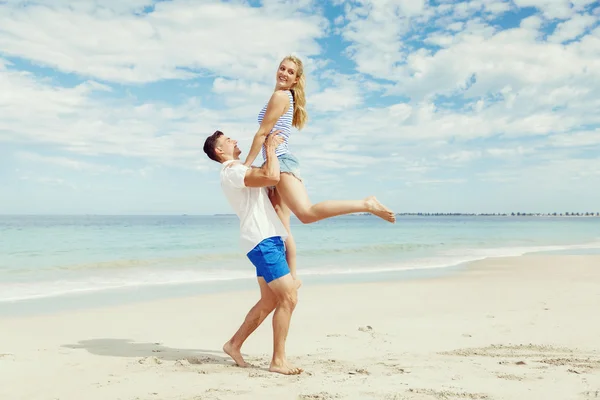 Casal feliz pulando em férias na praia — Fotografia de Stock