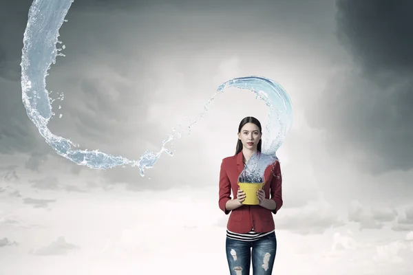 Girl pouring water from bucket . Mixed media — Stock Photo, Image