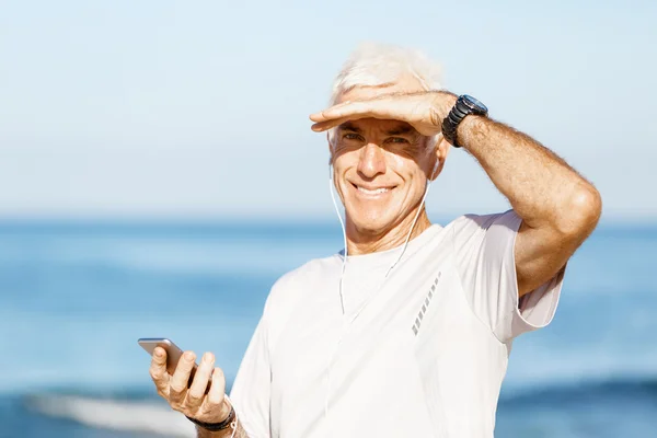 A mobil okos telefon, szabadban álló férfi futó — Stock Fotó