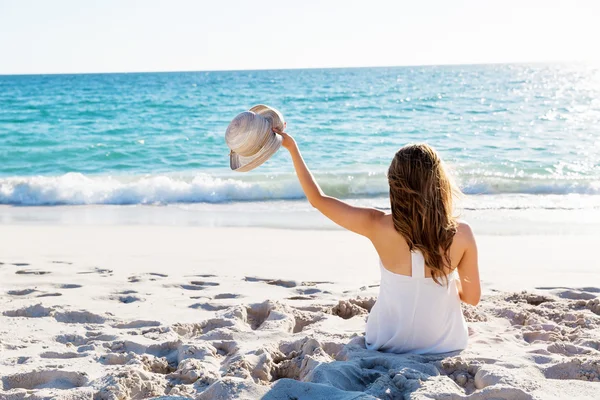 Jonge vrouw zittend op het strand — Stockfoto