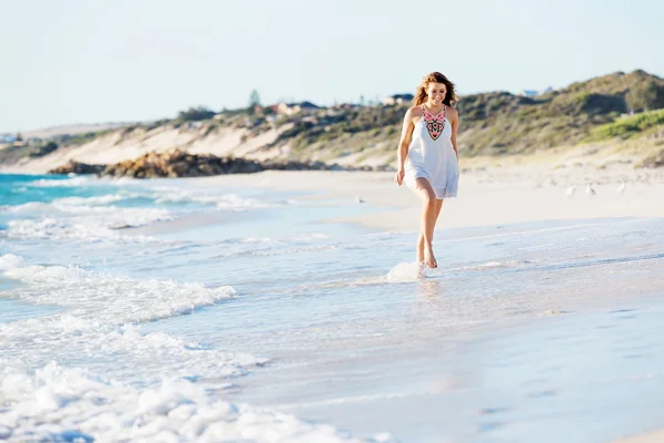 Giovane donna a piedi lungo la spiaggia — Foto Stock