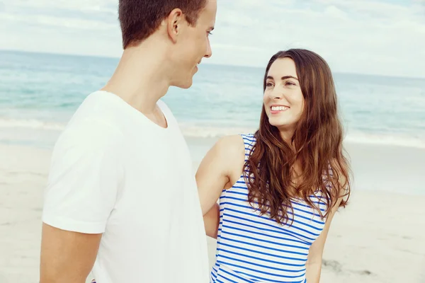 Romantico giovane coppia in piedi sulla spiaggia — Foto Stock