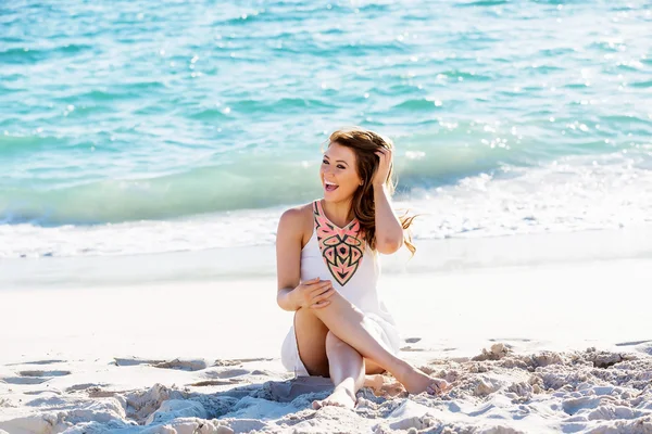 Jonge vrouw zittend op het strand — Stockfoto