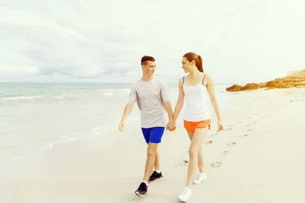Des coureurs. Jeune couple courant sur la plage — Photo