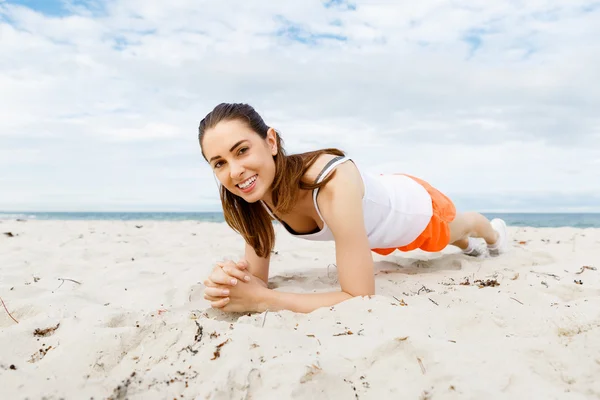 Mujer joven entrenando en la playa afuera —  Fotos de Stock