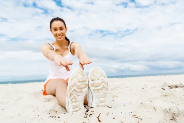 Mujer joven entrenando en la playa afuera —  Fotos de Stock