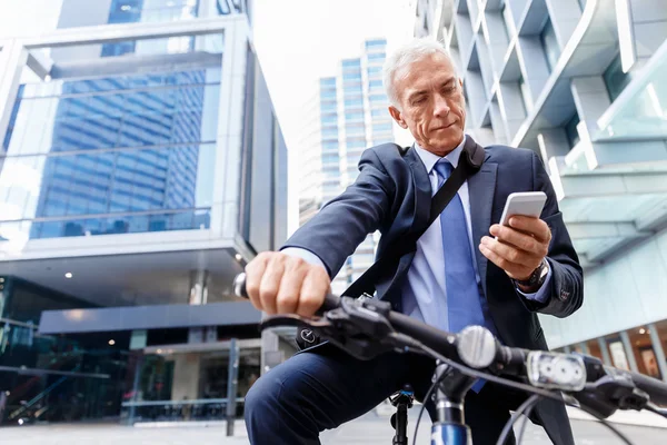 Successful businessman riding bicycle — Stock Photo, Image