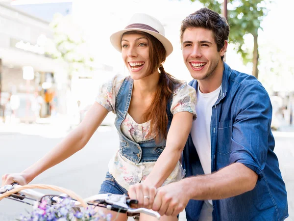 Happy couple in city with bike — Stock Photo, Image