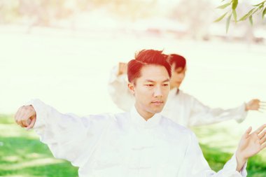 Yakışıklı adam Thai Chi yapıyor.