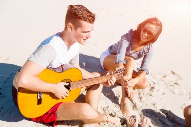 Sahilde gitar ile güzel gençler