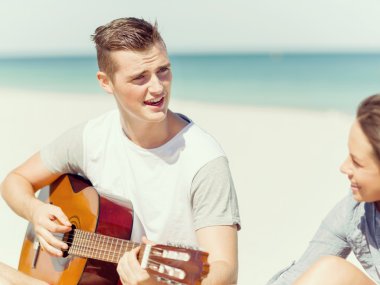 Sahilde gitar ile güzel gençler