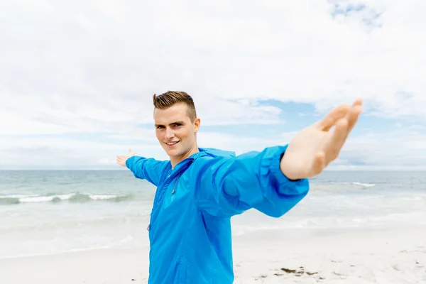 Young man in sport wear with outstretched arms — Stock Photo, Image
