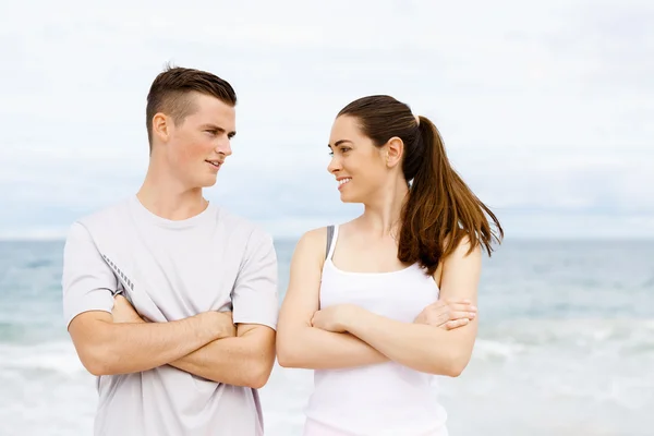 Young couple looking at each other on beach — Stock Photo, Image