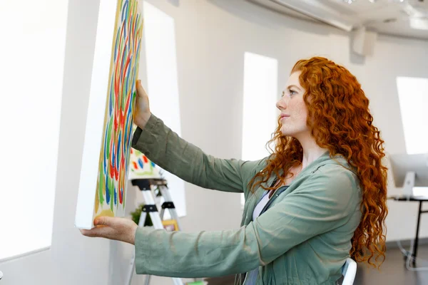 Young female artist with her picture — Stock Photo, Image