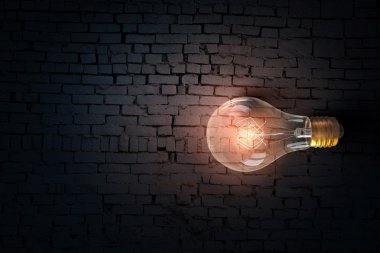 Parlayan ampul tuğla yüzeyinde. karışık teknik