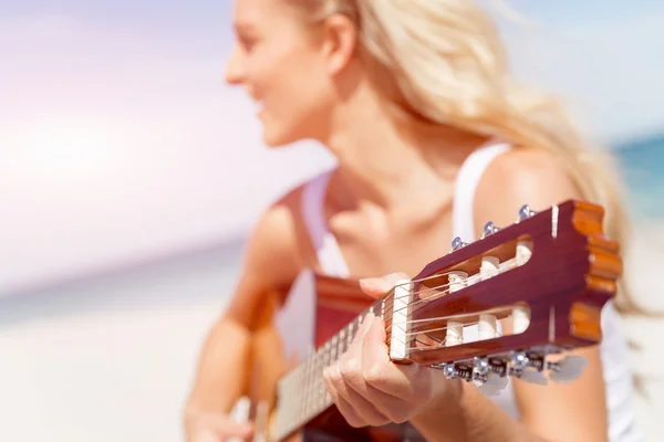 Bella giovane donna che suona la chitarra sulla spiaggia — Foto Stock