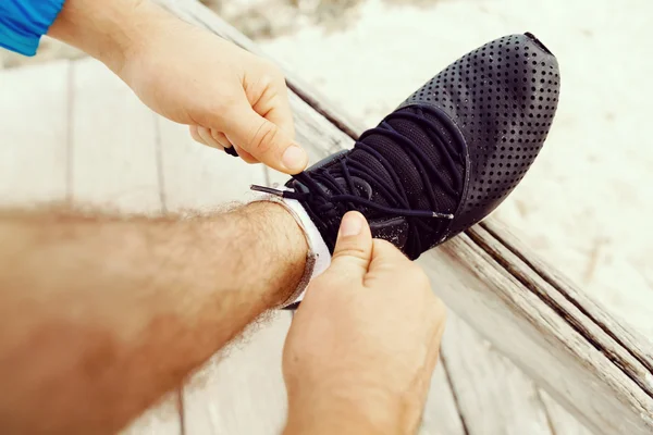 Běžec tkaničky boty a připravuje na běhání — Stock fotografie
