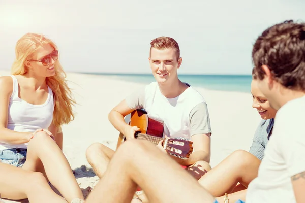 Hermosos jóvenes con guitarra en la playa —  Fotos de Stock