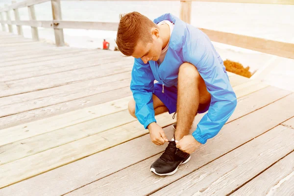 Corredor cadarços seus sapatos e se prepara para correr — Fotografia de Stock