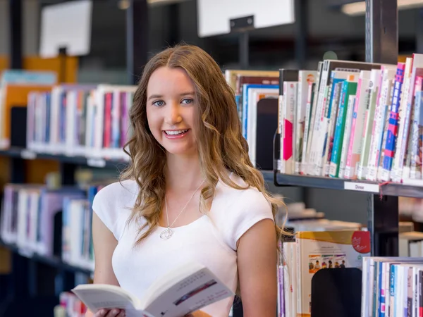 Kütüphaneden kitap tutan mutlu kız öğrenci — Stok fotoğraf