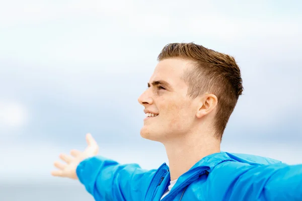 Young man in sport wear with outstretched arms — Stock Photo, Image