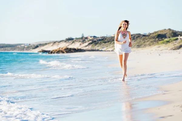 Jovem mulher caminhando ao longo da praia — Fotografia de Stock