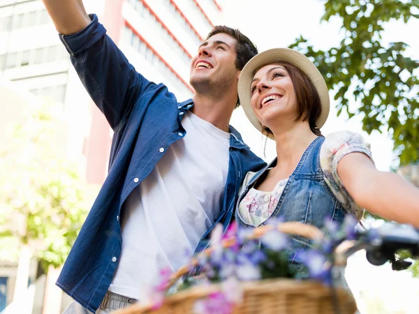 Happy couple in city with bike — Stock Photo, Image