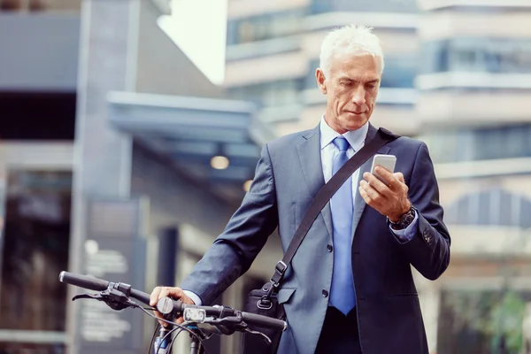 Homme d'affaires prospère à vélo avec téléphone portable — Photo