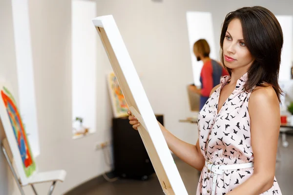Jeune femme caucasienne debout dans la galerie d'art devant des peintures — Photo