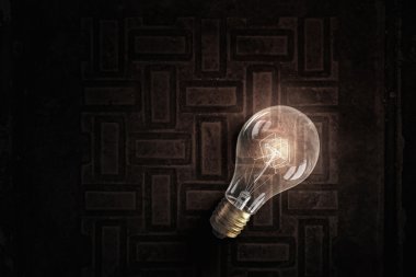 Parlayan ampul tuğla yüzeyinde. karışık teknik