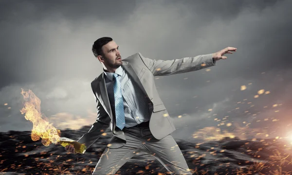 Businessman throwing petrol bomb . Mixed media — Stock Photo, Image