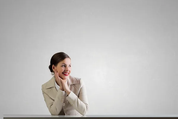 Businesswoman sitting at desk . Mixed media — Stock Photo, Image