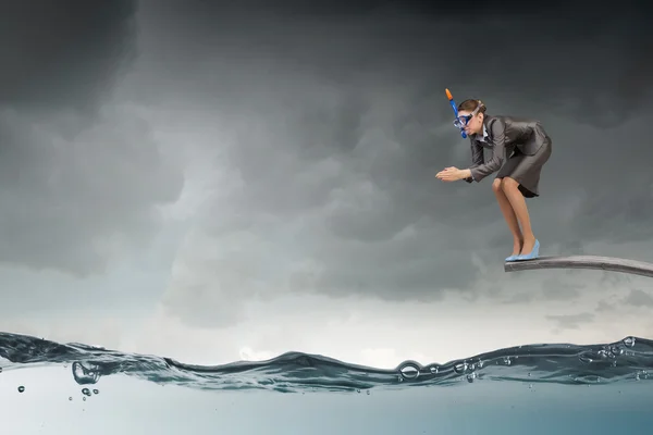 Бізнес-леді стрибає у воду. Змішані носії — стокове фото
