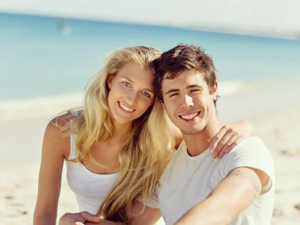 ロマンチックな若いカップルは、ビーチの上に座って — ストック写真