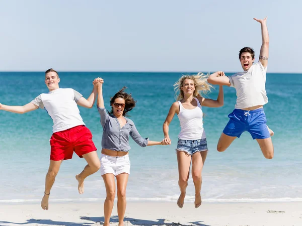 Gezelschap van jonge mensen op het strand — Stockfoto