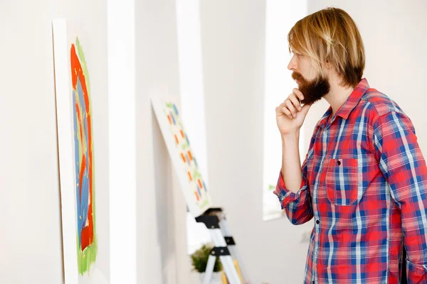 Hombre de pie en una galería y contemplando obras de arte —  Fotos de Stock