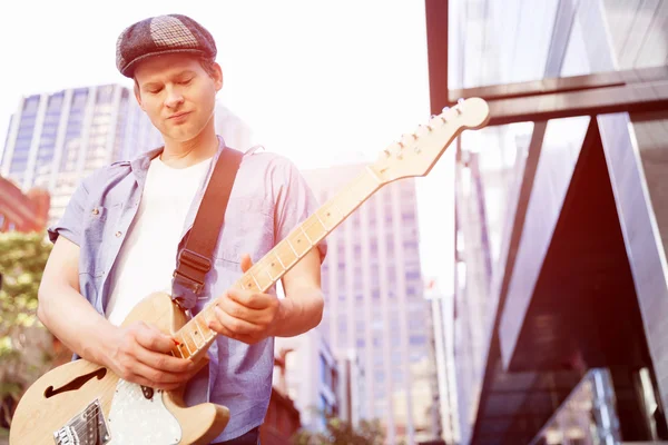Jovem músico com guitarra na cidade — Fotografia de Stock