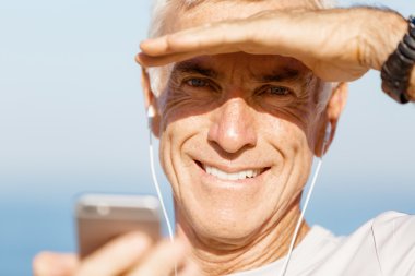 Erkek runner mobil akıllı telefonunu açık havada duran ile