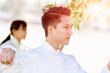 Yakışıklı adam Thai Chi yapıyor.