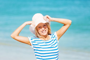 Genç bir kadın sahilde dinleniyor.