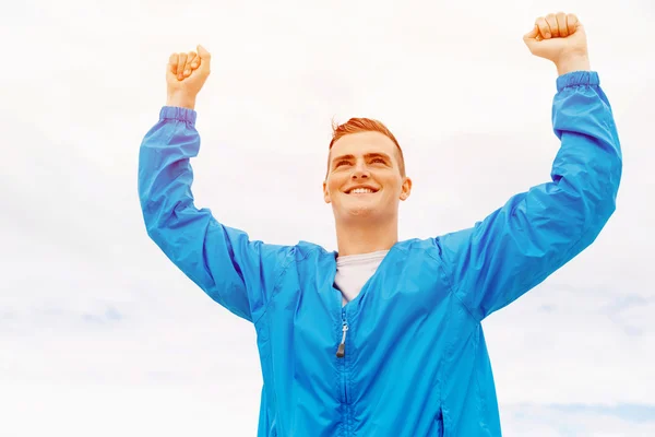 Young man in sport wear with outstretched arms — Stock Photo, Image