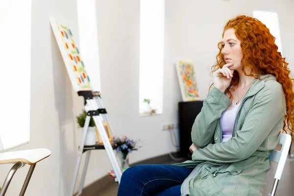 Young caucasian woman standing in art gallery front of  paintings — Stock Photo, Image