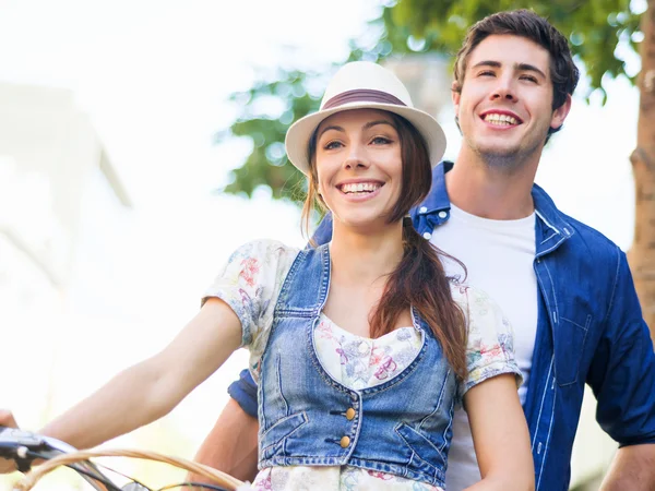 Pareja feliz en la ciudad con bicicleta —  Fotos de Stock