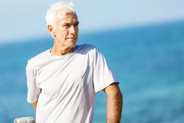 Man på stranden i sportkläder — Stockfoto