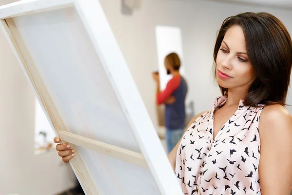 Jovem caucasiano mulher de pé na galeria de arte frente de pinturas — Fotografia de Stock