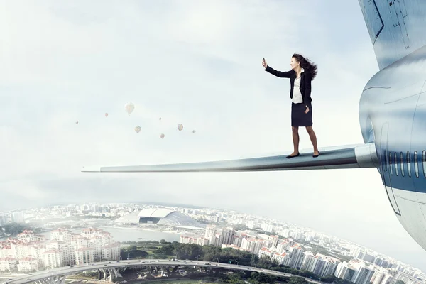 Femme dans l'aile de l'avion haut dans le ciel. Techniques mixtes — Photo