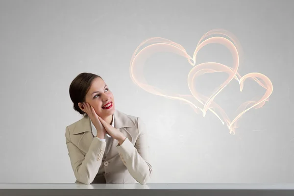 Businesswoman sitting at desk . Mixed media — Stock Photo, Image