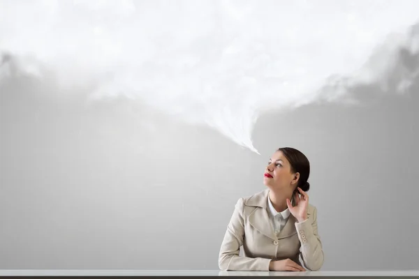 Businesswoman sitting at desk . Mixed media — Stock Photo, Image